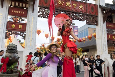 Lady posing with stilt walker in front of Pai Lau Gate at 2026 Cabramatta Lunar New Year.