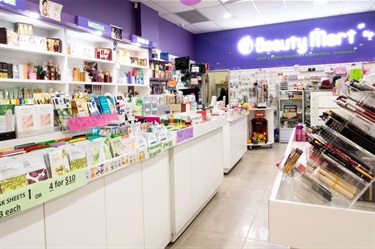 Shelf space displaying various beauty products like makeup brushes and face masks at Beauty Mart at Dutton Plaza