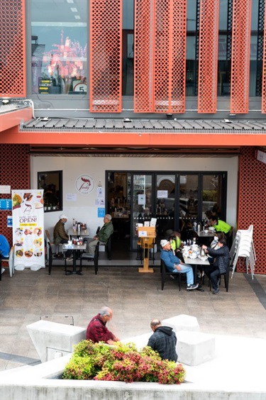 Street view of diners sitting outside Lam Ky Noodle House in Dutton Plaza
