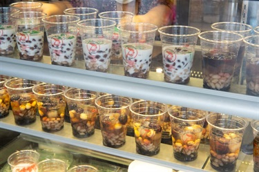 Glass display in front counter at Lam Ky Noodle House featuring various Vietnamese dessert drinks