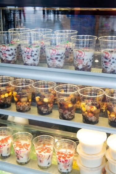 Glass display in front counter at Lam Ky Noodle House featuring various Vietnamese dessert drinks