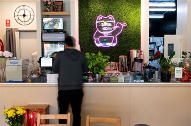 Customer paying for is meal at the counter in Lucky Cat Vietnamese Restaurant at Dutton Plaza