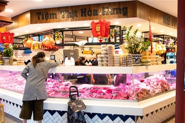 Customer purchasing fresh meats over the counter at the Premium Meat Market in Dutton Plaza